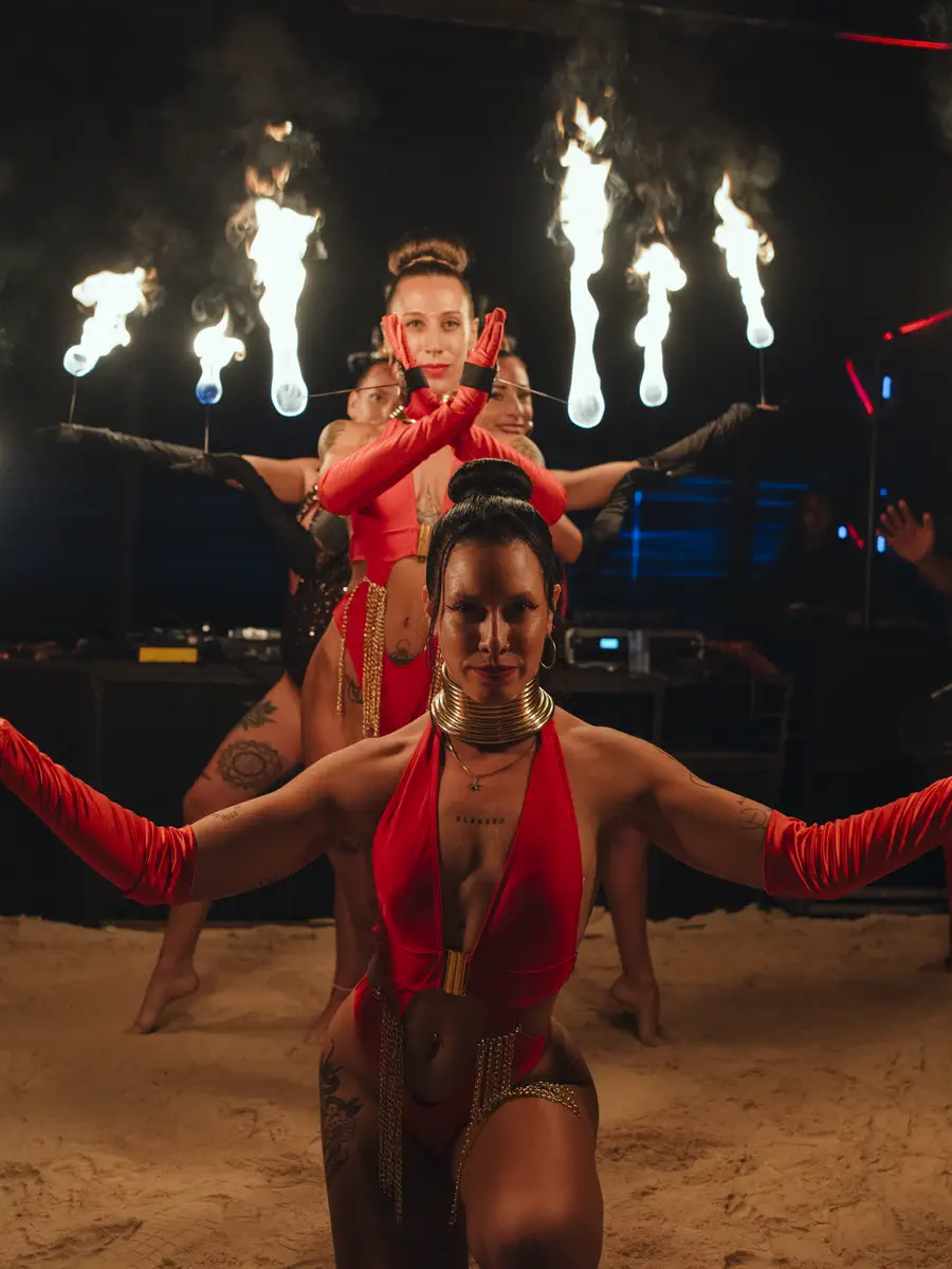 Cuatro artistas de fuego en formación sobre la playa, de noche